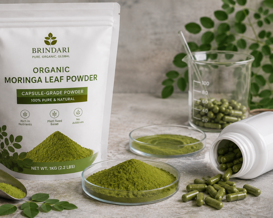 Brindari capsule-grade moringa leaf powder pouch beside petri dishes of powder, a beaker and bottle of green capsules
