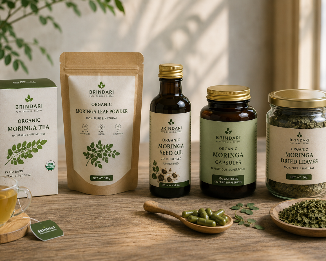 Brindari retail line-up: moringa tea box, leaf powder pouch, seed oil bottle, capsules jar, and dried leaves jar on a wooden table